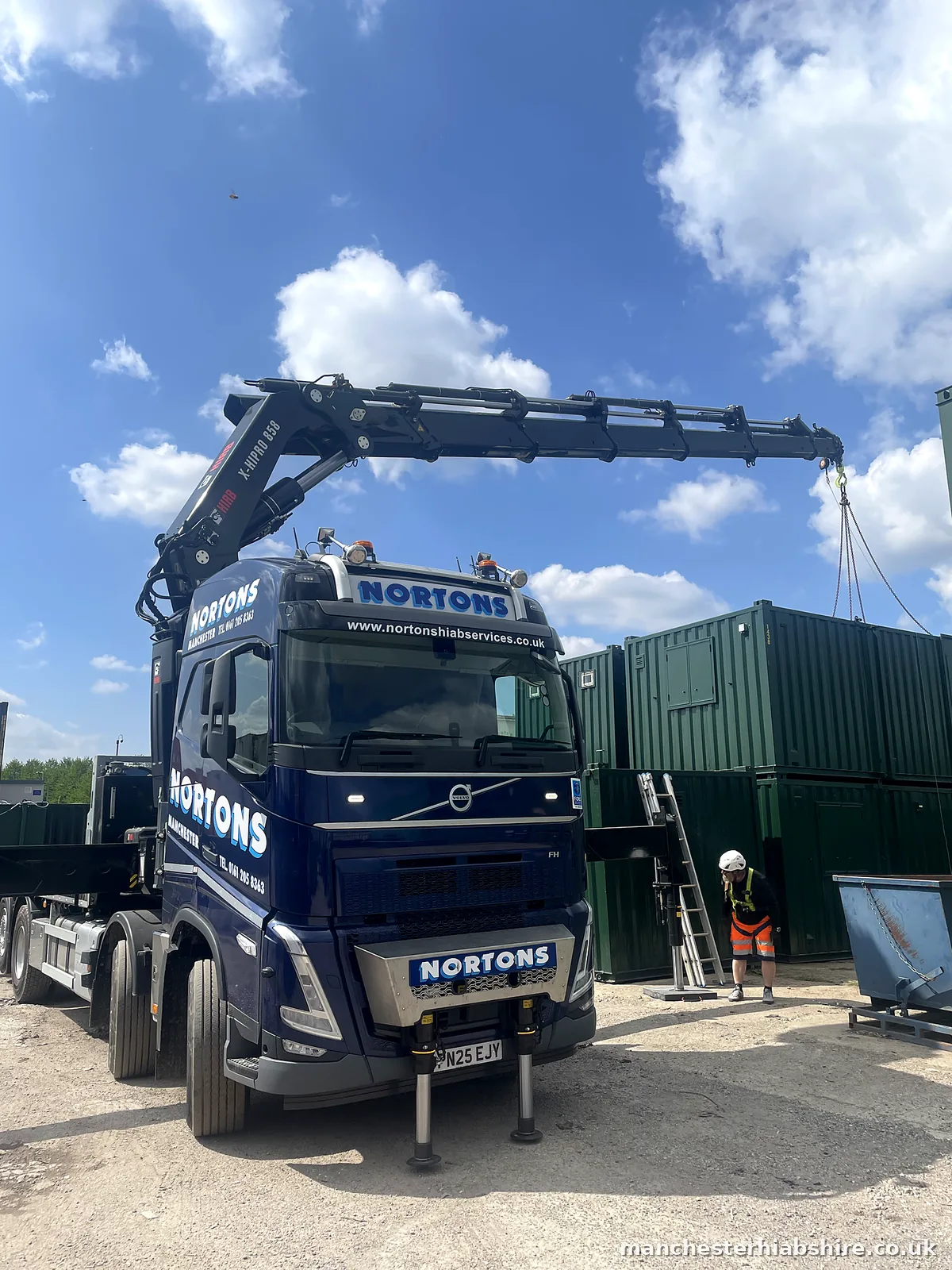 HIAB boom extended with the chain hook above stacked shipping containers