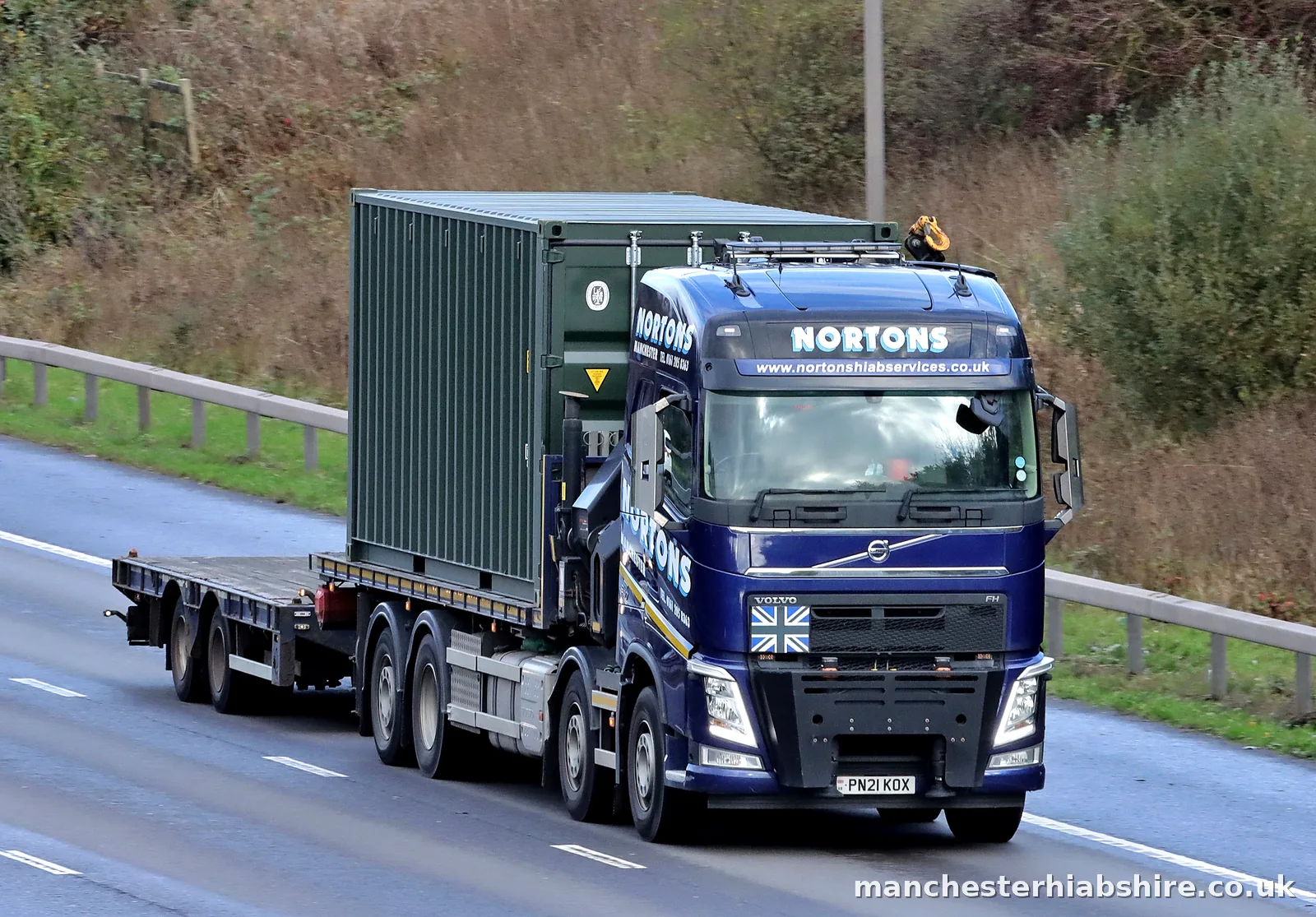 HIAB lorry and trailer carrying a shipping container on the motorway