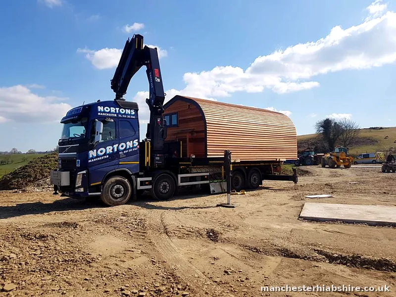 Timber barrel roof glamping pod on the trailer in open countryside