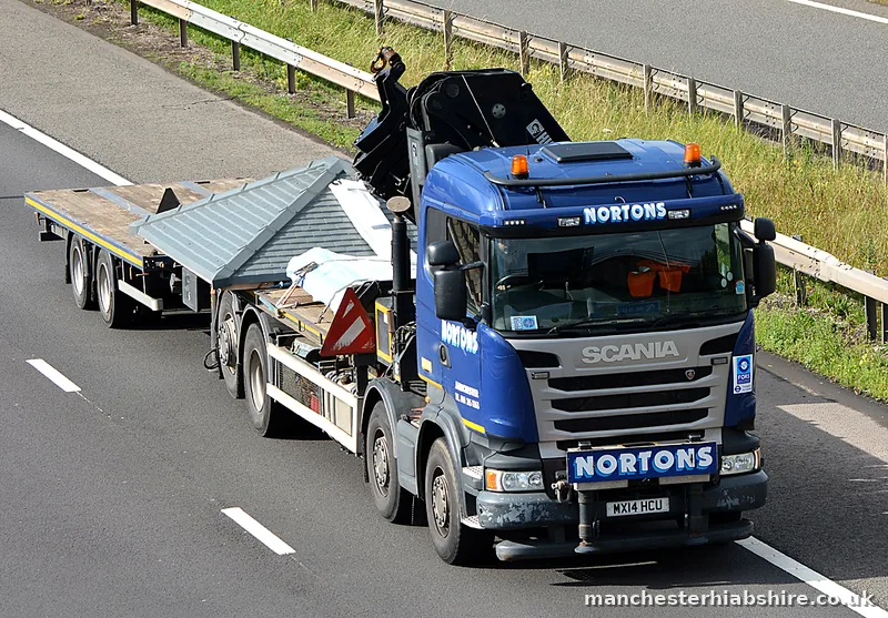 Articulated HIAB with an empty flat trailer on the move