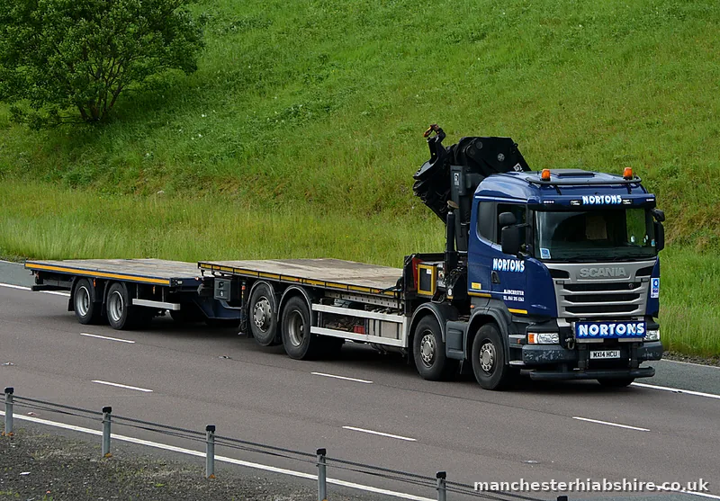 HIAB outfit with a clear flat trailer on the open road