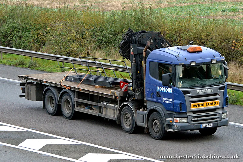 HIAB flatbed lorry with a wide load board travelling on the motorway