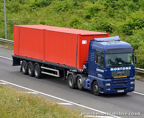 HIAB lorry carrying a red shipping container southbound on the motorway