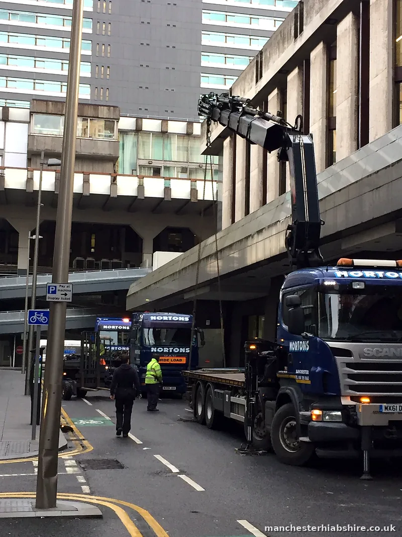Two HIAB lorries nose to tail under a concrete walkway