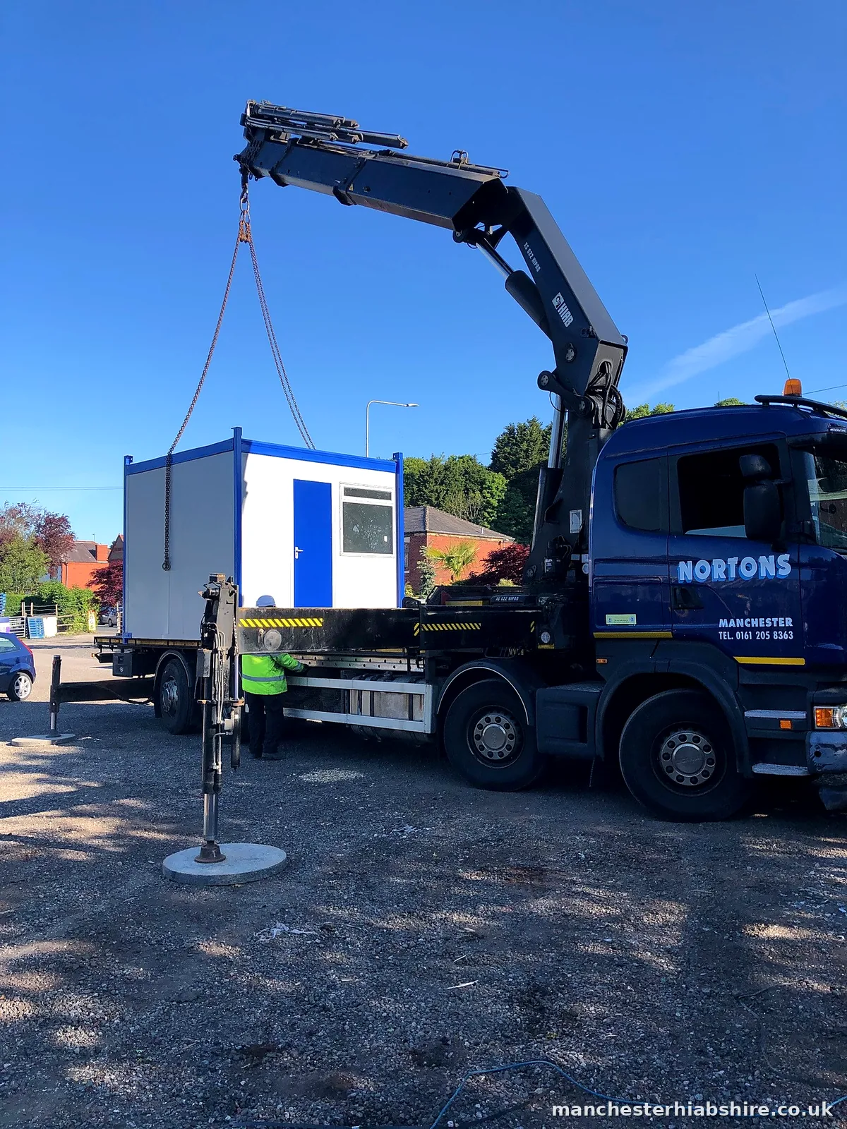 Cabin lifting off the lorry bed with a banksman guiding it