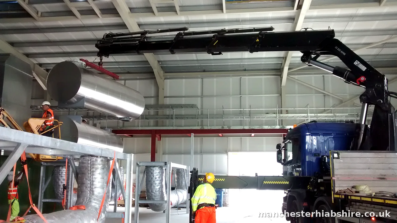 Insulated ducting lifted on the HIAB inside a plant building with crew in protective equipment
