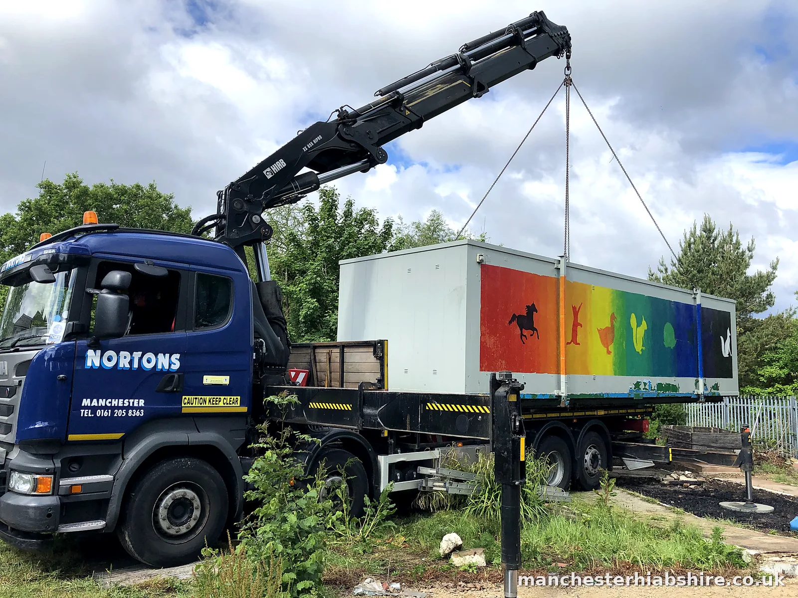 Painted cabin with an animal silhouette mural lifted on the HIAB