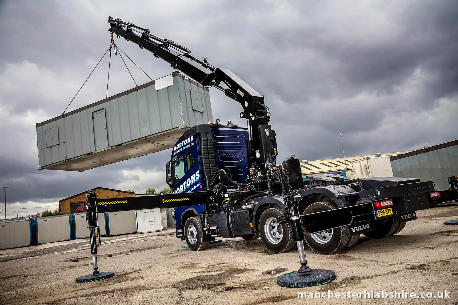 HIAB lifting a long steel unit clear of the lorry bed on chains