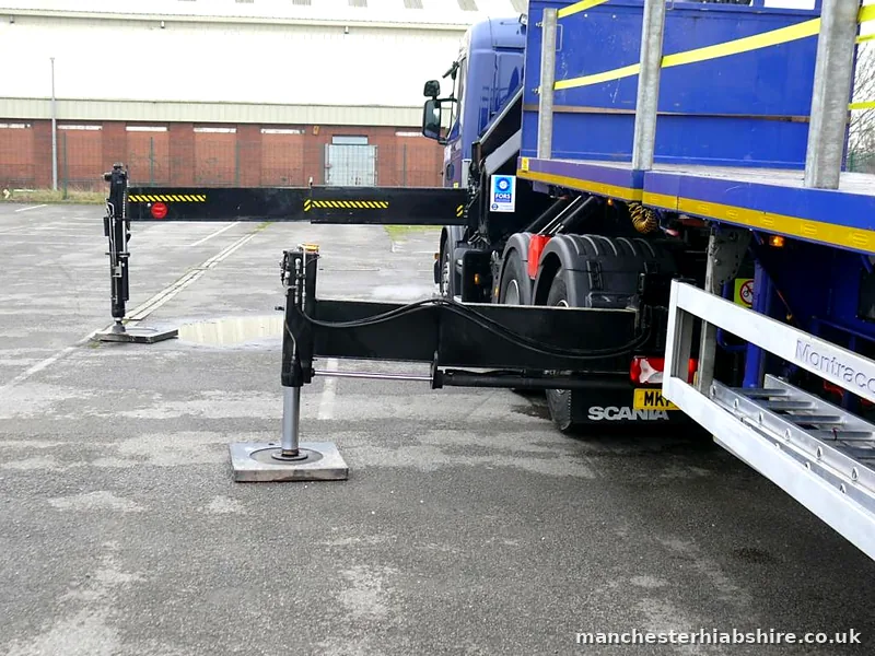 Outrigger legs extended on either side of a lorry before a lift