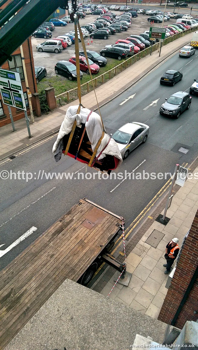 Wrapped piano suspended on the hook above the carriageway