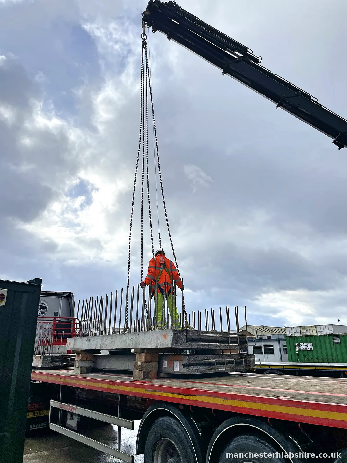 Precast concrete being lifted on site with reinforcement bar in the foreground