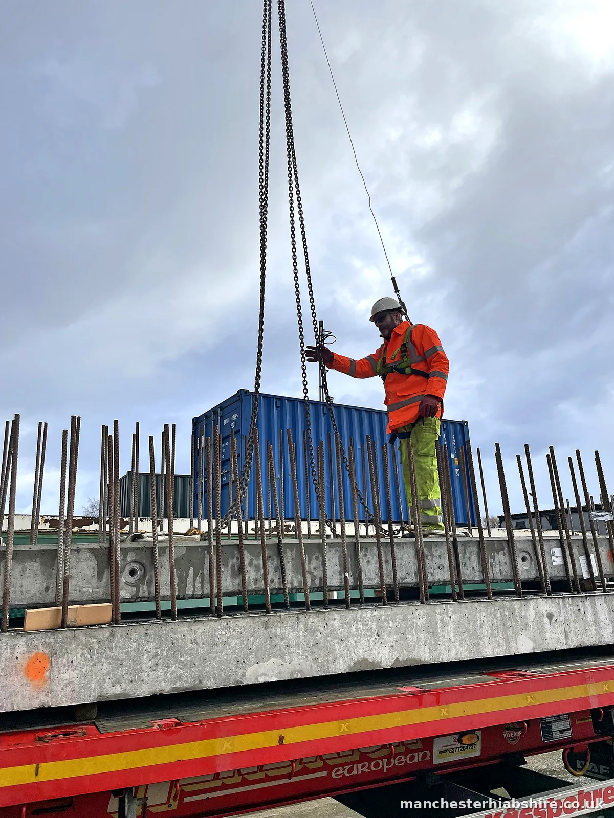 Precast concrete plank being landed onto timber bearers on the trailer