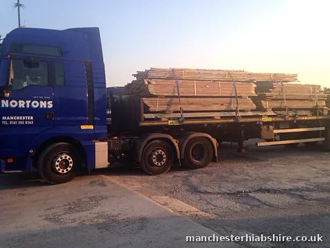 Loaded scaffold trailer of boards, tube and bagged fittings in low sun