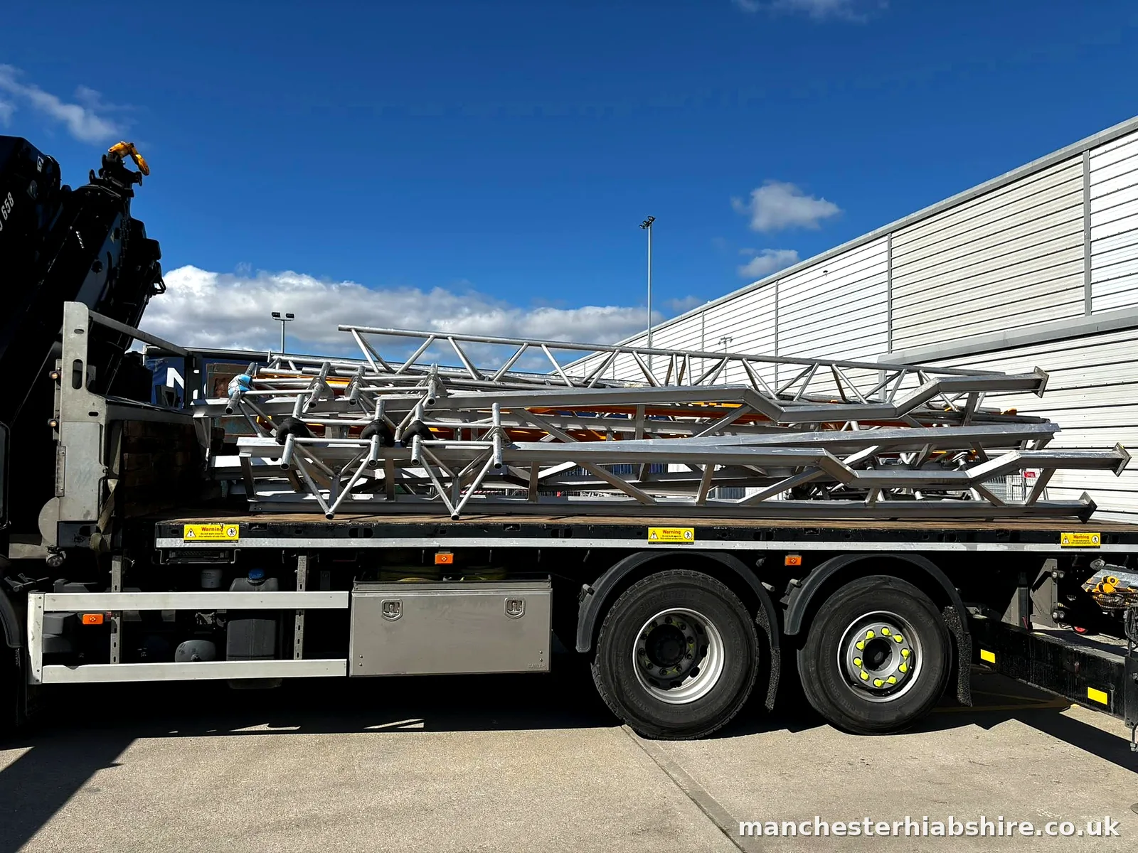 Flatbed loaded with scaffold and steel tower sections