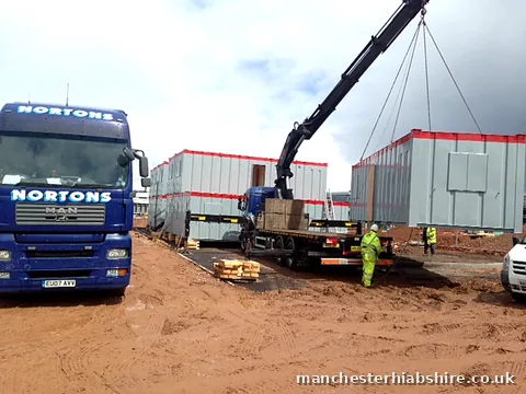 Modular cabin set into position by the HIAB with crew in protective equipment