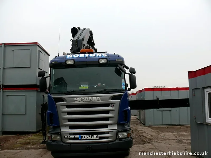 HIAB lorry front on between rows of site cabins in the storage yard