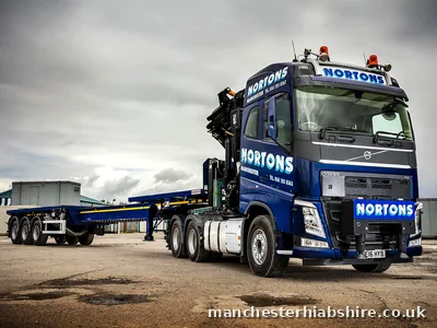 Articulated HIAB tractor unit with a four axle extendable trailer fully extended