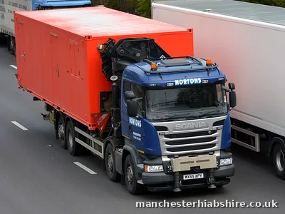 Container on a HIAB lorry in the inside lane of the motorway