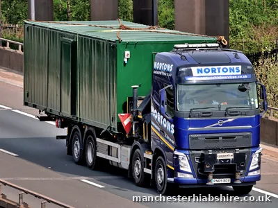 HIAB lorry carrying two steel container units chain lashed to the bed
