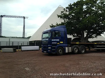 Articulated lorry and trailer on site in front of a festival stage
