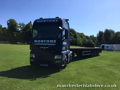 Articulated lorry with an extendable flat trailer on festival grass