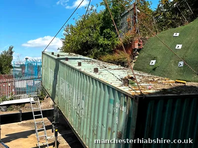 Forty foot shipping container lifted clear of the trailer bed on chains