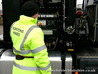 Driver working the HIAB control station at the side of the lorry