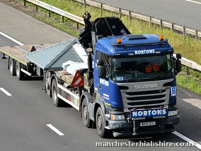 Articulated HIAB with an empty flat trailer on the move