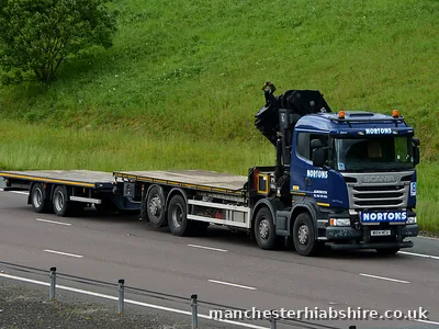 HIAB outfit with a clear flat trailer on the open road