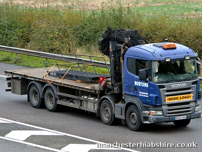 HIAB flatbed lorry with a wide load board travelling on the motorway