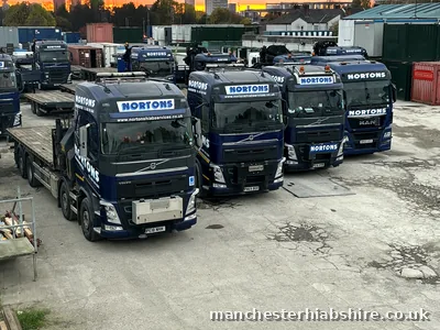 Line of HIAB lorries and trailers in the yard at the end of the day