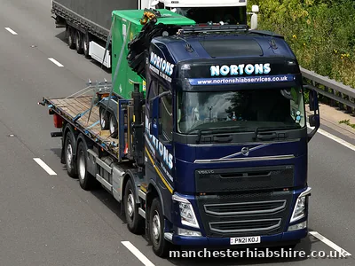 HIAB flatbed running on the motorway with the lifting arm folded behind the cab