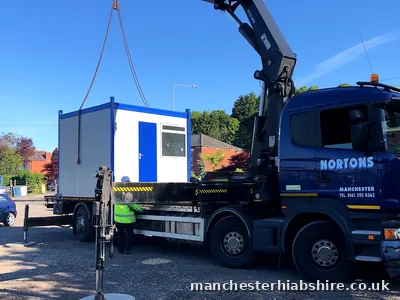 Cabin lifting off the lorry bed with a banksman guiding it