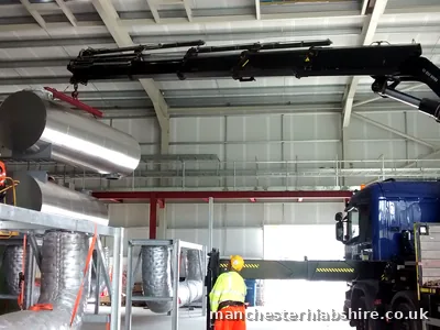 Insulated ducting lifted on the HIAB inside a plant building with crew in protective equipment