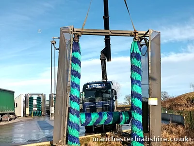 Rigid HIAB lifting a truck wash unit into position