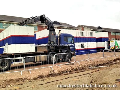 HIAB lorry alongside a completed cabin run behind barriers