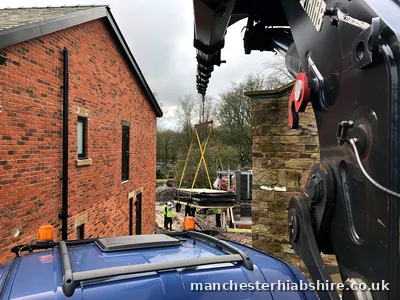Lorry mounted crane rigged to lift a long wrapped pool shell