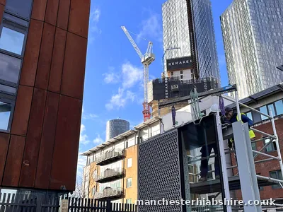 Panel being lifted between buildings in Manchester