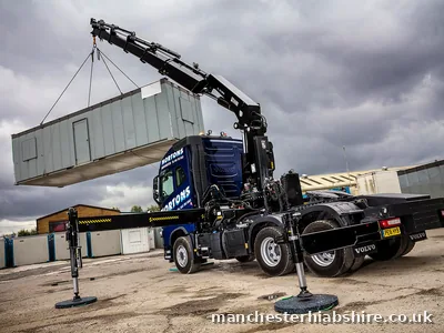 HIAB lifting a long steel unit clear of the lorry bed on chains