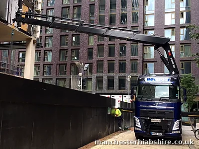 Boom extended up a city centre building to collect a hoist, crew on the ground