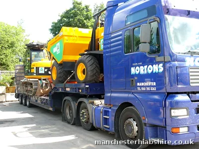 Low loader with plant machinery loaded, side view