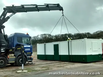 Site cabin lifted on the HIAB with two crew levelling it into place