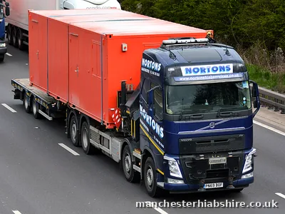 Orange container carried on a HIAB lorry on the road
