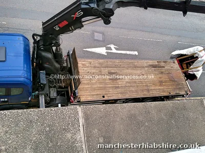 Looking down on the HIAB flatbed in the road with a wrapped piano swinging out on the boom