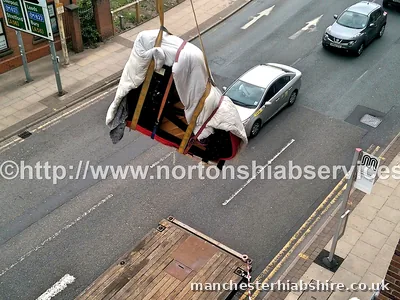 Wrapped piano suspended on the hook above the carriageway