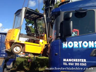 Forklift truck slung on chains beside the HIAB lorry cab during the lift