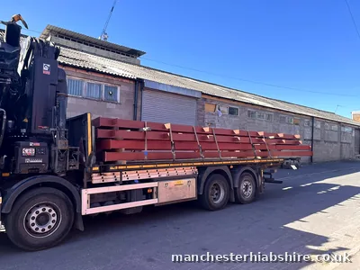 Flatbed loaded with steel beams on a Manchester job