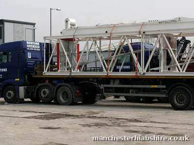 Articulated lorry loaded with white steel jib sections