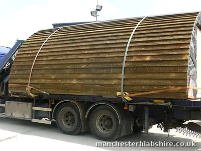 Flatbed carrying a large timber clad barrel pod