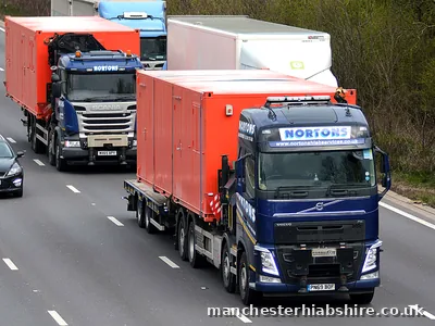 Two HIAB lorries carrying container loads on the same stretch of road